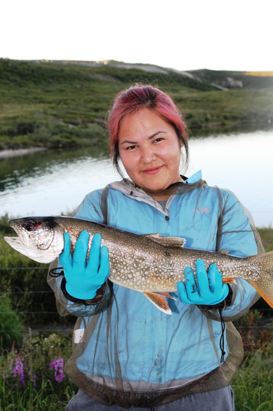 Summer student Teya Wetrade with one of the four Lake Trout she caught at Daring Lake this summer  (Photo:  GNWT/Stephanie Yuill)