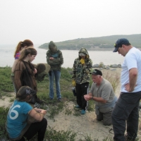 Roman Lamouelle (middle, in camouflaged jacket) learning about archaeological sites on the tundra from archaeologist Tom Andrews
